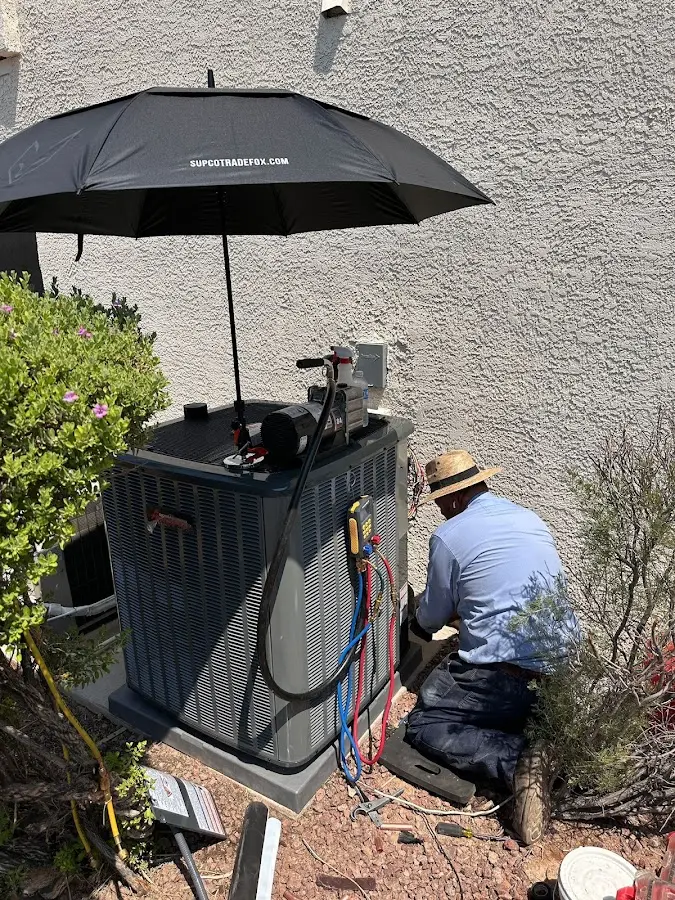 HVAC technician performing outdoor AC maintenance in River Rouge